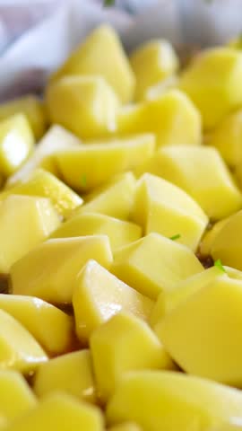 Oven baked whole potatoes with seasoning and herbs in metalic tray. Roasted potatoes in jackets. Top view. Close up.