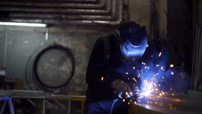 Industrial Welder in Protective Mask Welding Metal Components with Precision in a Factory Workshop for Heavy-Duty Manufacturing and Structural Fabrication. High quality 4k footage - Powered by Shutterstock - Get 15% off with code: PIKWIZARD15