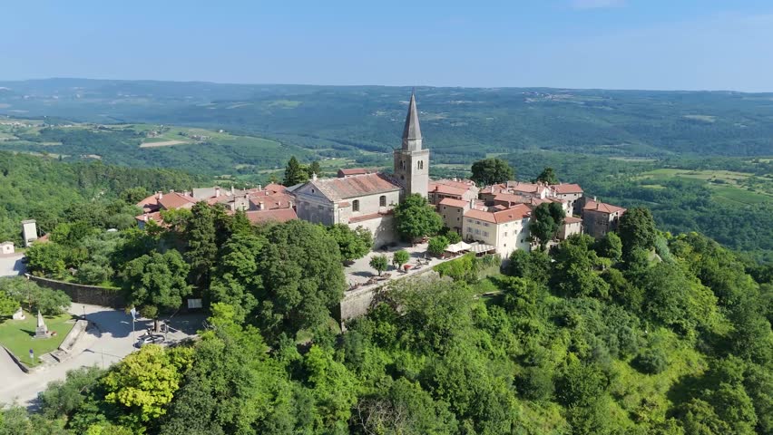Old town of Groznjan - Grisignana in Croatian Istria. Historic place known as Town of Artists. Church tower and old buildings on a scenic hilltop. Tourism, attractions and travel concepts. Aerial, 4K