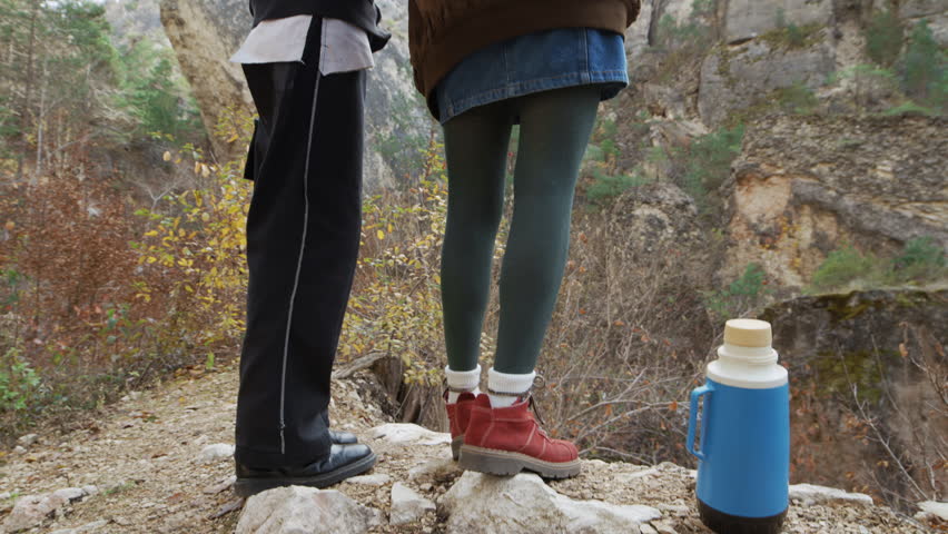 Tilt up shot of a Couple Exploring Breathtaking Mountain Scenery at Sunrise