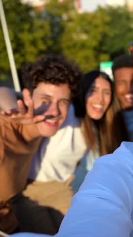 Frontal view of multi-ethnic group of happy friends taking selfie together in the street
