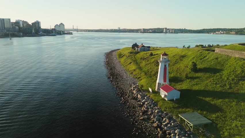A Beautiful Aerial View Of The Ancient Lighthouse On A Small Island In Halifax Harbor, Nova Scotia. The Sunset Illuminates The Historic Landmark, Surrounded By Calm Waters And Scenic Views.