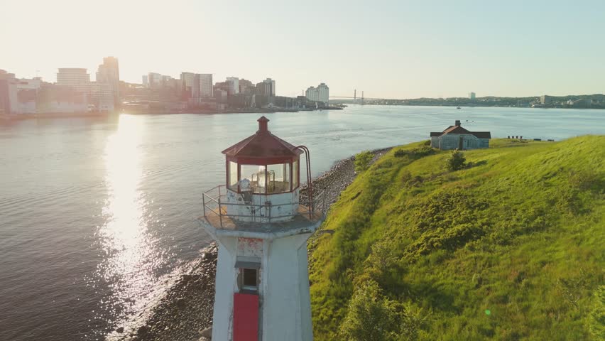 A Beautiful Aerial View Of An Ancient Lighthouse Standing On A Small Island In Halifax Harbor, Nova Scotia. The Sunset Paints The Sky With Vibrant Colors, Adding Magic To This Scenic Landmark.