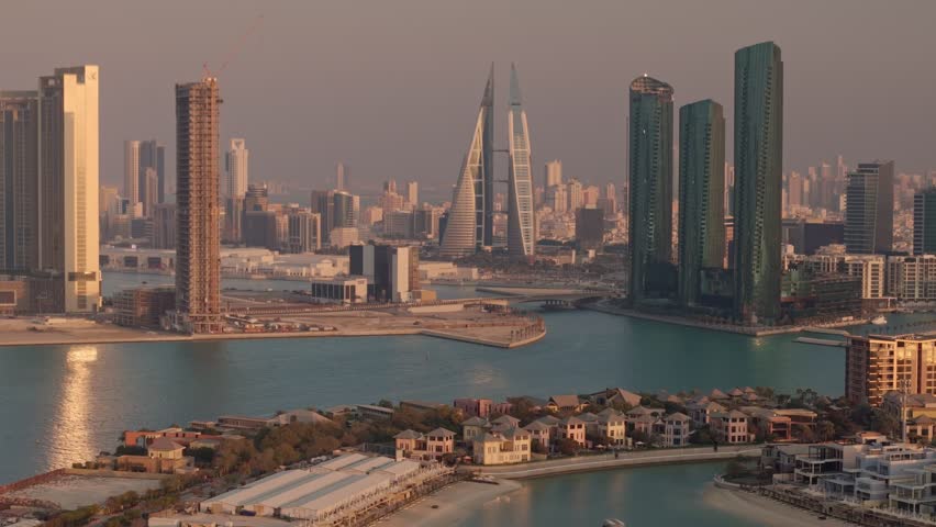 Bahrain, aerial view over luxury waterside condos towards skyscrapers and downtown Manama, warm late afternoon light