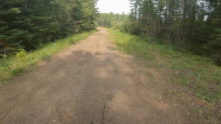 Point of view from mountain bike riding through mud puddles. Rider’s shadow in frame
