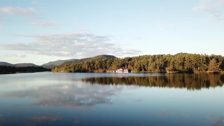 Lake Placid village in the Adirondack Mountains in Essex County, New York, United States, drone footage scenic reflection of still water surface
