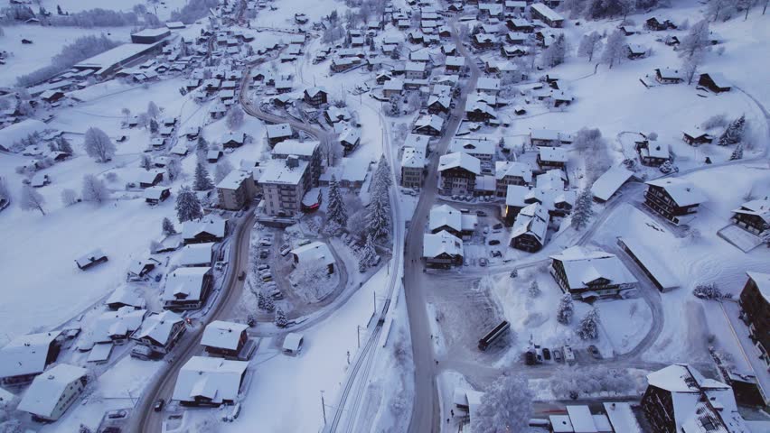 pushing in over freshly snow covered grindelwald village at dusk