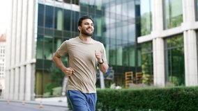 Young adult male runner jogging along a park alley on a city street. Handsome active man in a t-shirt enjoys jogging outdoors. Athlete on morning workout. Concept of sport and healthy lifestyle - Powered by Shutterstock - Get 15% off with code: PIKWIZARD15
