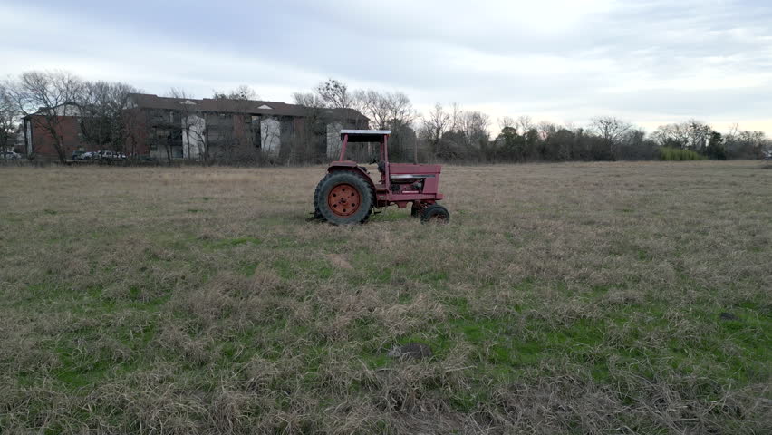 Old Tractor in a field - flying towards the right side of the tractor in 4K