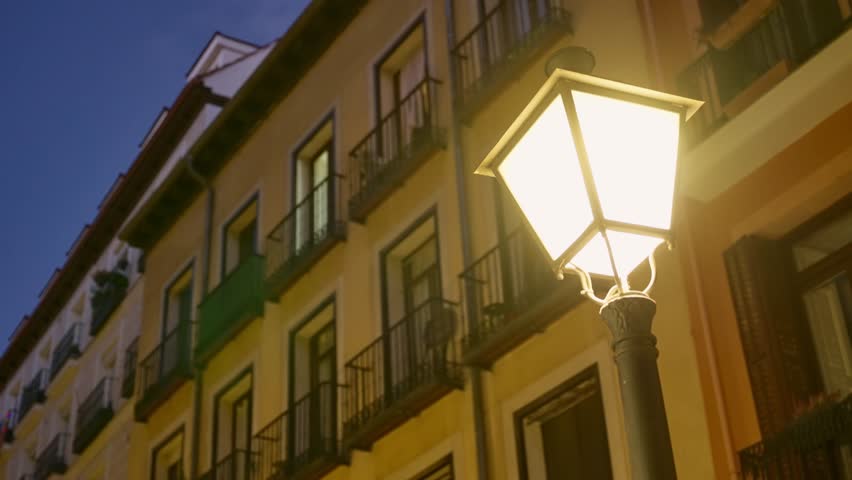 Street lamp shining bright at night in city or urban street in Europe. Close up on classic and traditional light in Madrid, Spain. Lighting the city in yellow dimmed colors