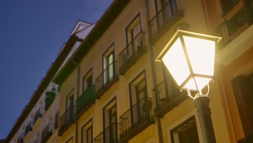 Street lamp shining bright at night in city or urban street in Europe. Close up on classic and traditional light in Madrid, Spain. Lighting the city in yellow dimmed colors