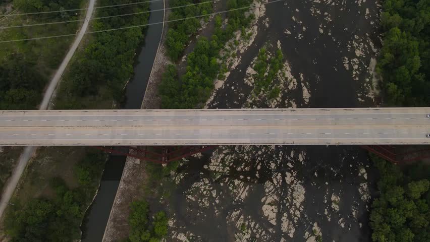 Cars passing over a bridge that passes over the shenandoah River in West Virginia.
