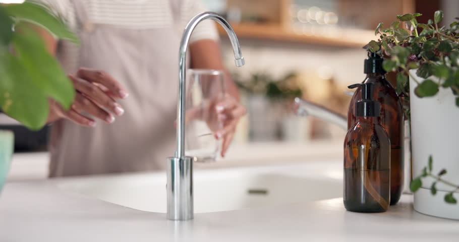 Person, hands and tap water in glass with thirst, hydration and healthy skin detox at home. Woman, open faucet and cup in kitchen for drink, fresh beverage and filtration system at sink for nutrition