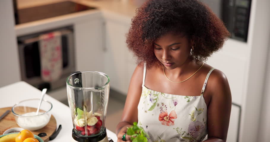 Blender, health or woman with fruits in morning breakfast for diet nutrition, detox and vitamins. Juice, strawberry or yogurt with drinks preparation for vegan shake, lunch or smoothie in kitchen