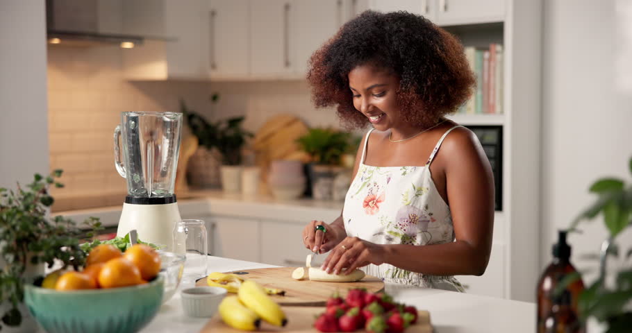 Blender, detox and happy woman cutting fruits in morning breakfast for diet nutrition, health and vitamins. Juice, banana and drink preparation for vegan shake, lunch or smoothie in house kitchen