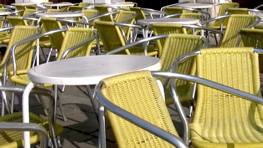 Early morning in the town square. Street cafe. Tables and yellow wicker chairs