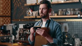 Cheerful smiling Caucasian barista guy male entrepreneur man drinking coffee beverage in cafeteria cafe seller worker tasting cappuccino energy drink owner waiter work restaurant shop small business - Powered by Shutterstock - Get 15% off with code: PIKWIZARD15