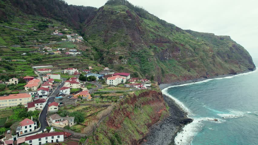 Aerial 4k drone circle view of coastline and cute coastal town at Porto Moniz in Madiera, Portugal
