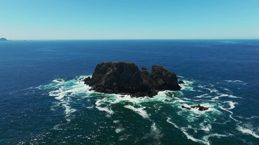 An aerial view showcasing the stunning rock formations in the ocean off Playa La Morita, Tenacatita, Jalisco, Mexico, with crystal-clear waters surrounding them.