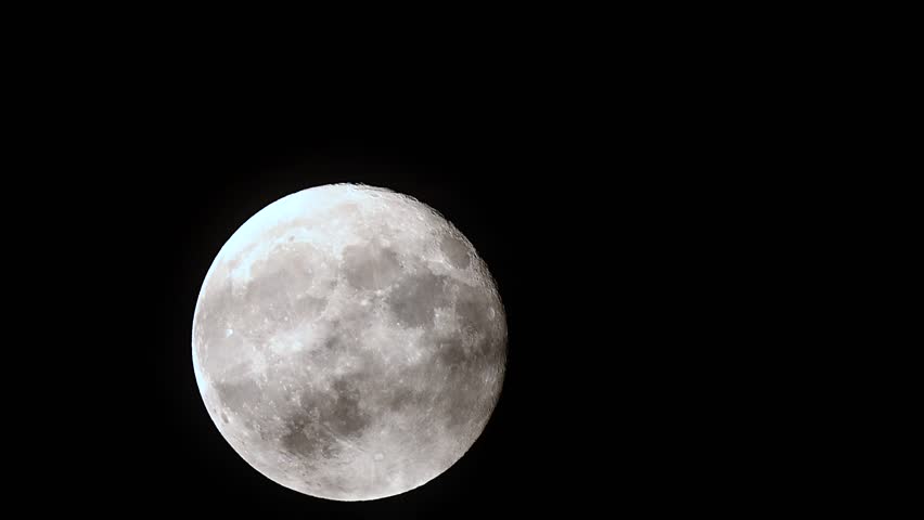 Full moon rise through drifting dark clouds in stunning cinematic time lapse at night
