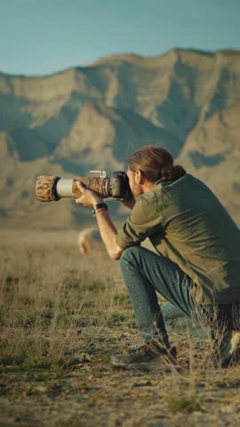 Wildlife photographer tourist taking pictures in wild desert nature.