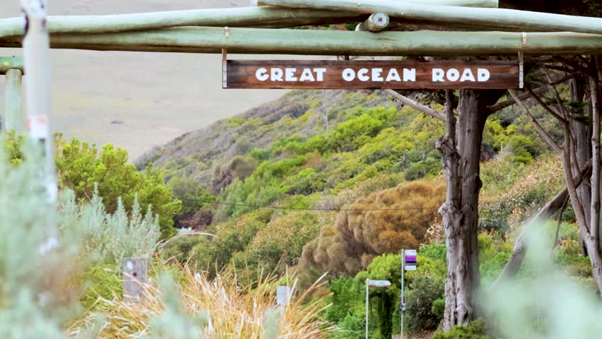 Iconic road sign amidst lush greenery and hills