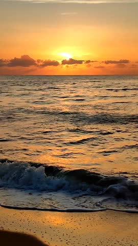 Beautiful sunrise on sea. Rising sun over sea. Sun shining from behind clouds in sky above horizon at sea. Seascape. Sea landscape dawn sunset. Natural dawning sundown background. Vertical