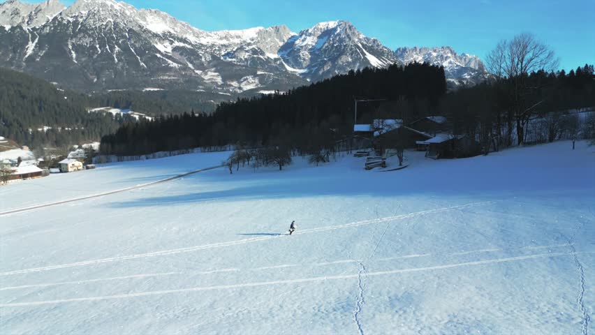 Wide sweeping drone shot of backcountry snowboarder in Austria