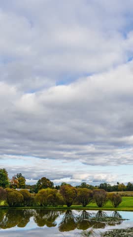 Vertical day to night timelapse in verdant countryside. From cloudy weather till clear sky sunset with fog settling on the ground in the evening.