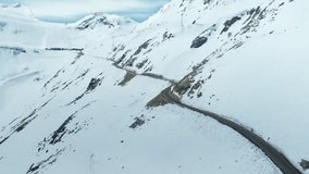 Aerial drone shot of camera fly over road high up in mountain valley leading towards mountain range in distance - Powered by Shutterstock - Get 15% off with code: PIKWIZARD15