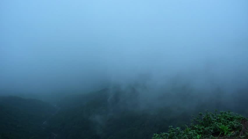 A mesmerizing view of Kavlesad Point, Maharashtra, India, covered in dense fog. The misty atmosphere creates a mysterious and serene vibe, with green hills barely visible through the thick clouds.