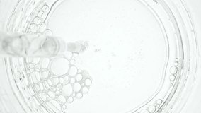 Transparent air Bubbles come out from lab pipet and bursting on the surface of clear fluid in Petri dish. The medicine concept, health care, treatment. Macro Shot of Natural Organic Cosmetics - Powered by Shutterstock - Get 15% off with code: PIKWIZARD15