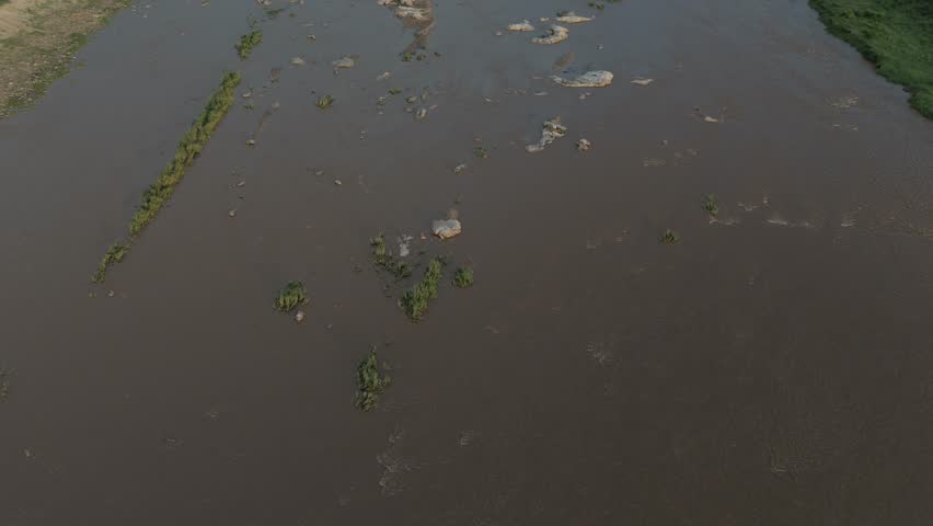 Cinematic aerial tilt of a flowing seasonal river that