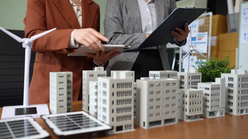 Two colleagues discussing data working and tablet, laptop with on Construction Site project, green energy and solar panel concept. - Powered by Shutterstock - Get 15% off with code: PIKWIZARD15