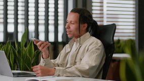 American business man male businessman guy at desk talking mobile phone microphone in office saying smartphone using smart technology dictate commands loudspeaker recording voice mail audio message - Powered by Shutterstock - Get 15% off with code: PIKWIZARD15