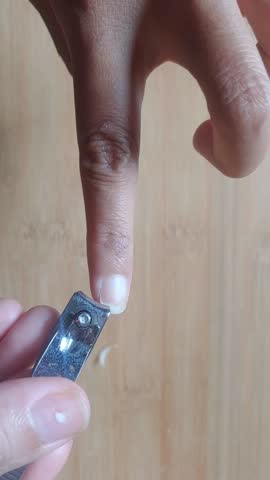 close up of someone cutting nails using a nail clipper