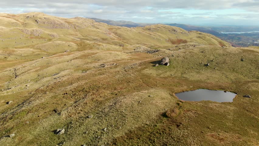 Aerial view of Stickle Tarn lake, located in the Lake District, Cumbria, UK. Popular tourist attractions in Great Langdale valley, famous for its glacial ribbon lakes and rugged mountains.