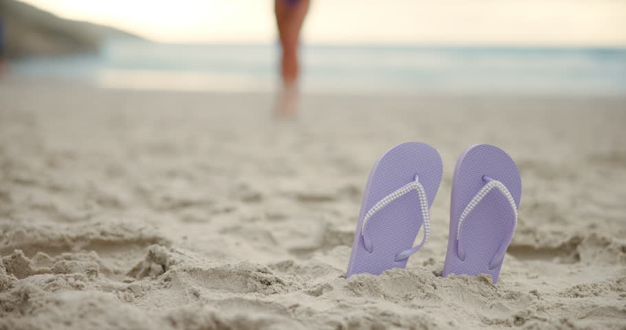 Beach, sandals and feet of woman on sand running to comfortable footwear in outdoor holiday. Closeup, girl walking and barefoot female person picking up flip flops or slippers on vacation break