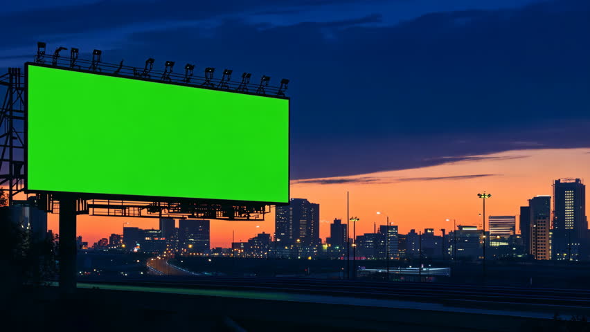 Large green screen chroma key billboard, sunset. Blank empty canvas for advertising. Urban street design. Modern city life. Mock up for ad. Mockup space for image outdoor. Clean advertisement poster.