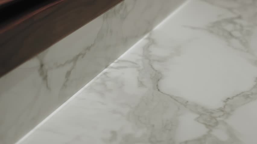 Elegant white marble surface with subtle and exquisite veining patterns. Camera moves