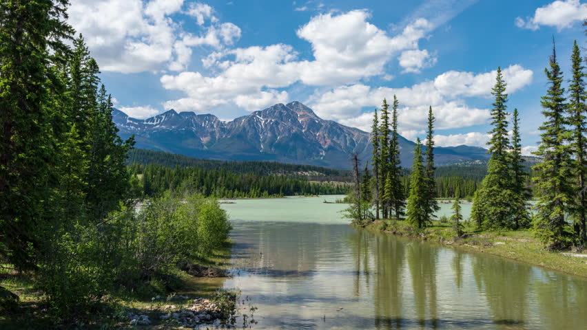 Jasper National Park Beautiful landscape. Canadian Rockies, Alberta, Canada. Pyramid Mountain and Athabasca River in summer sunny day. Time-lapse.