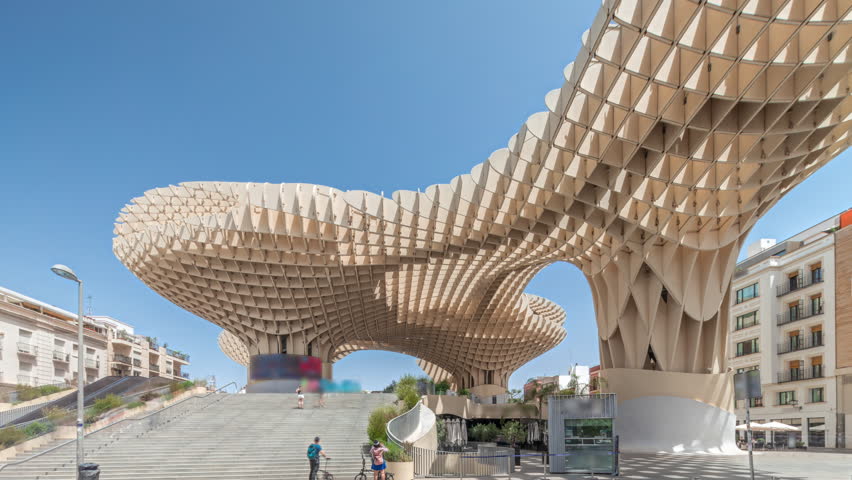 Metropol Parasol in Encarnacion Square timelapse hyperlapse, futuristic wooden structure with panoramic walkway and an archaeological museum. Blue sky, stairs, traffic and cityscape in Seville, Spain