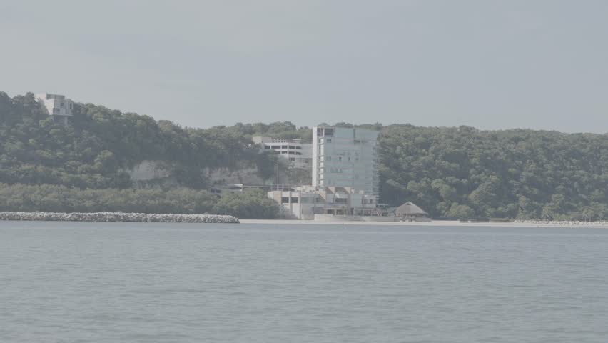 A building on the beach from the perspective of a passing boat