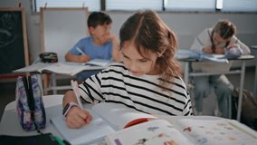Little girl holding pen thinking in classroom closeup. Serious schoolgirl listening lesson writing answers. Smart kid sitting desk learning in school auditorium. Thoughtful attentive student schooling - Powered by Shutterstock - Get 15% off with code: PIKWIZARD15