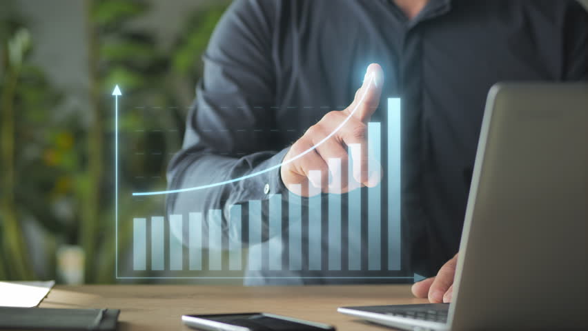 male finger drawing growing business graphic charts on virtual screen,person at the laptop computer showing economical financial growth,reaching target goal
