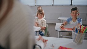 Curious kids enjoying lesson at cozy class room. Closeup unrecognizable teacher explaining material talking to cute children. Two funny boys speaking each other at elementary school. Education concept - Powered by Shutterstock - Get 15% off with code: PIKWIZARD15