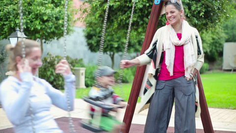 Happy girlfriends on playground with son, steadicam shot
 Stock Video
