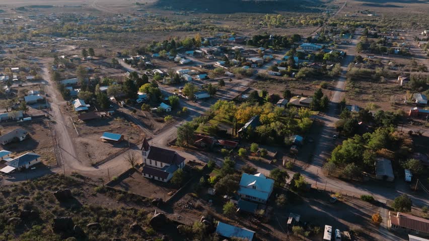 Pulling away to reveal mountaintop overlooking rural Texas Town at Sunrise, Fort Davis in West Texas small town golden hour drone city orbit in 4k