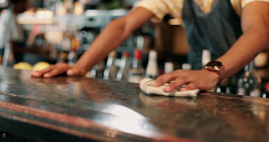 Hands, bar and hygiene for table, cleaning and bartender with cloth for bacteria, disinfection and person. Business, employee and wiping of counter for dirt, hospitality and prevention of germs