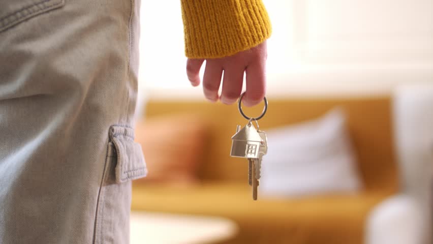 Newly Wed Couple Holding Hands Holding Keys On House Keychain. - closeup shot